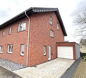 Moderne Doppelhaushälfte mit Garage und Gartenbereich.